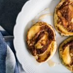 Cinnamon roll pancakes with a brown sugar cinnamon swirl on a white plate