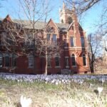 Red brick building and crocuses on the Smith College campus in Northampton, Massachusetts