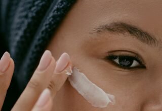 Woman applying a light layer of night cream to her cheek, as in a tretinoin routine